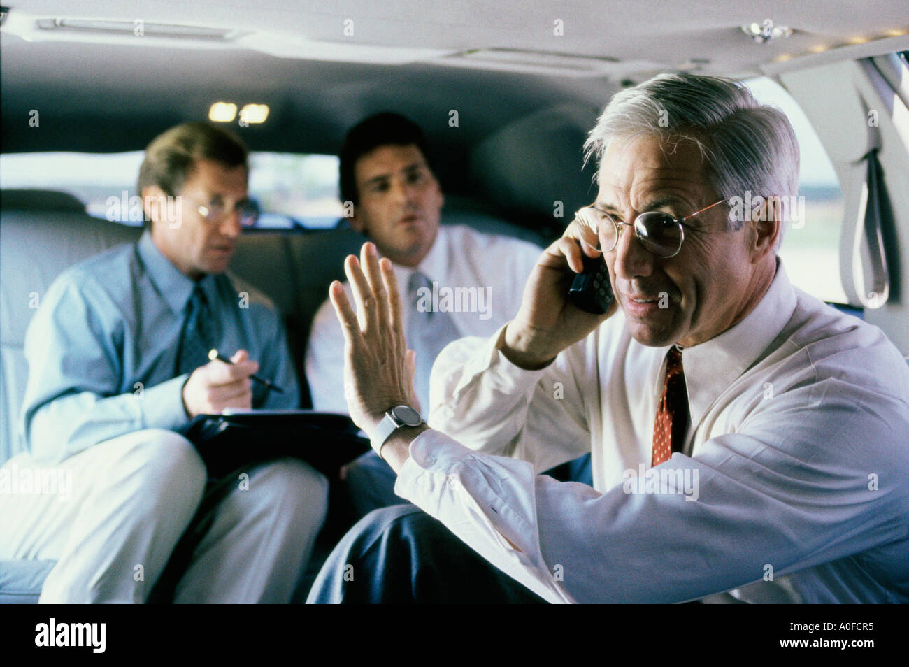 Three businessmen sitting in a car Stock Photo - Alamy