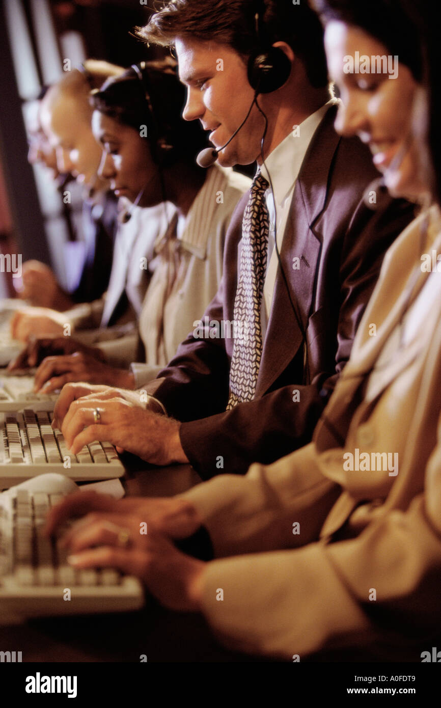 Group of business executives wearing headsets working on computers Stock Photo