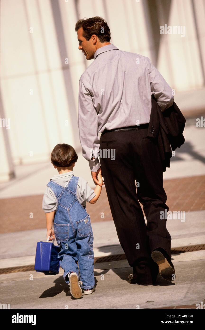 Rear view of a father walking with his son Stock Photo - Alamy
