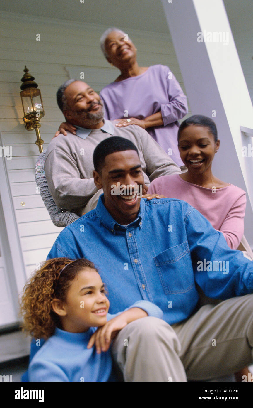 Grandparents sitting on the front porch with their son and