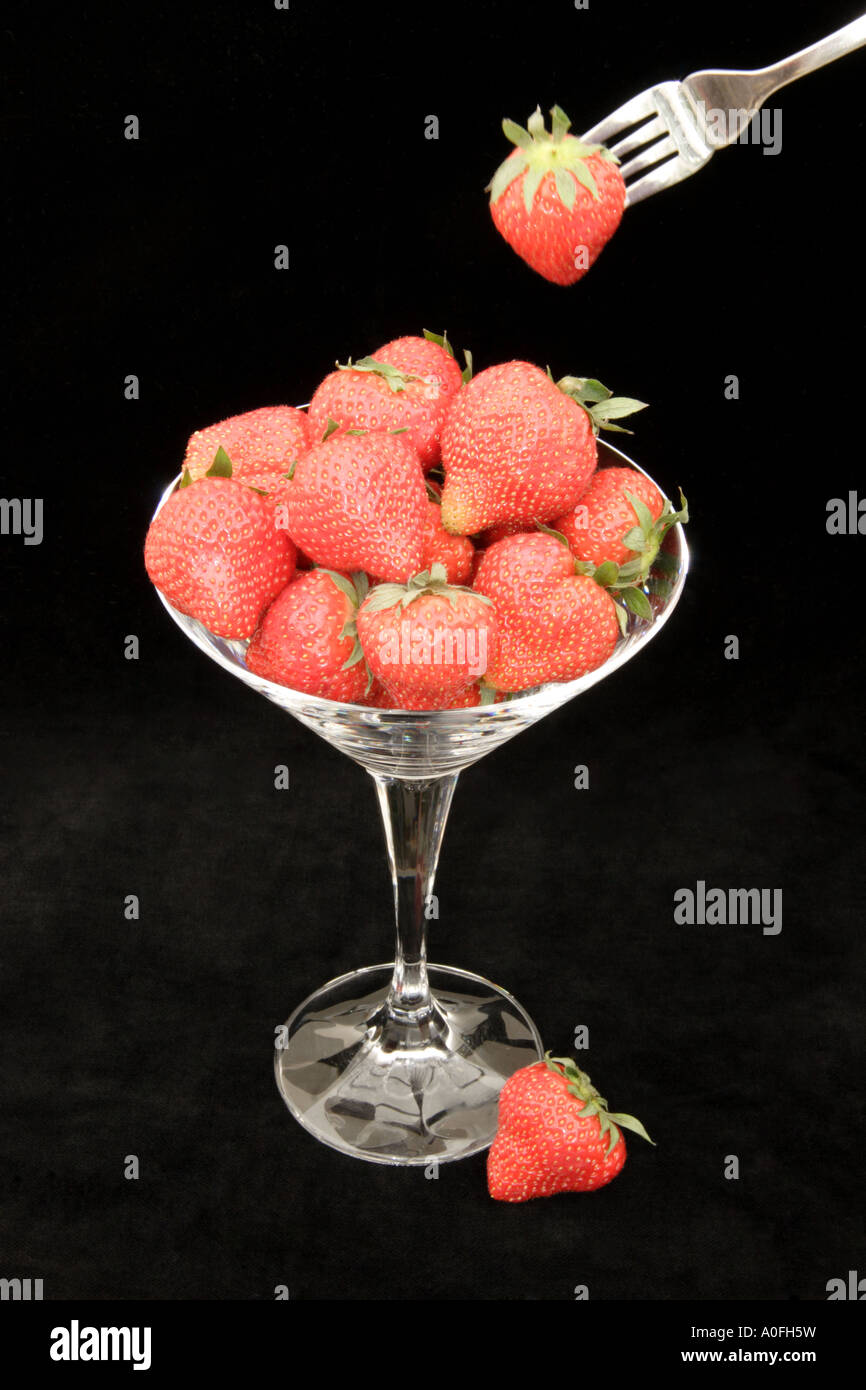 Strawberries in a glass on a black background Stock Photo - Alamy