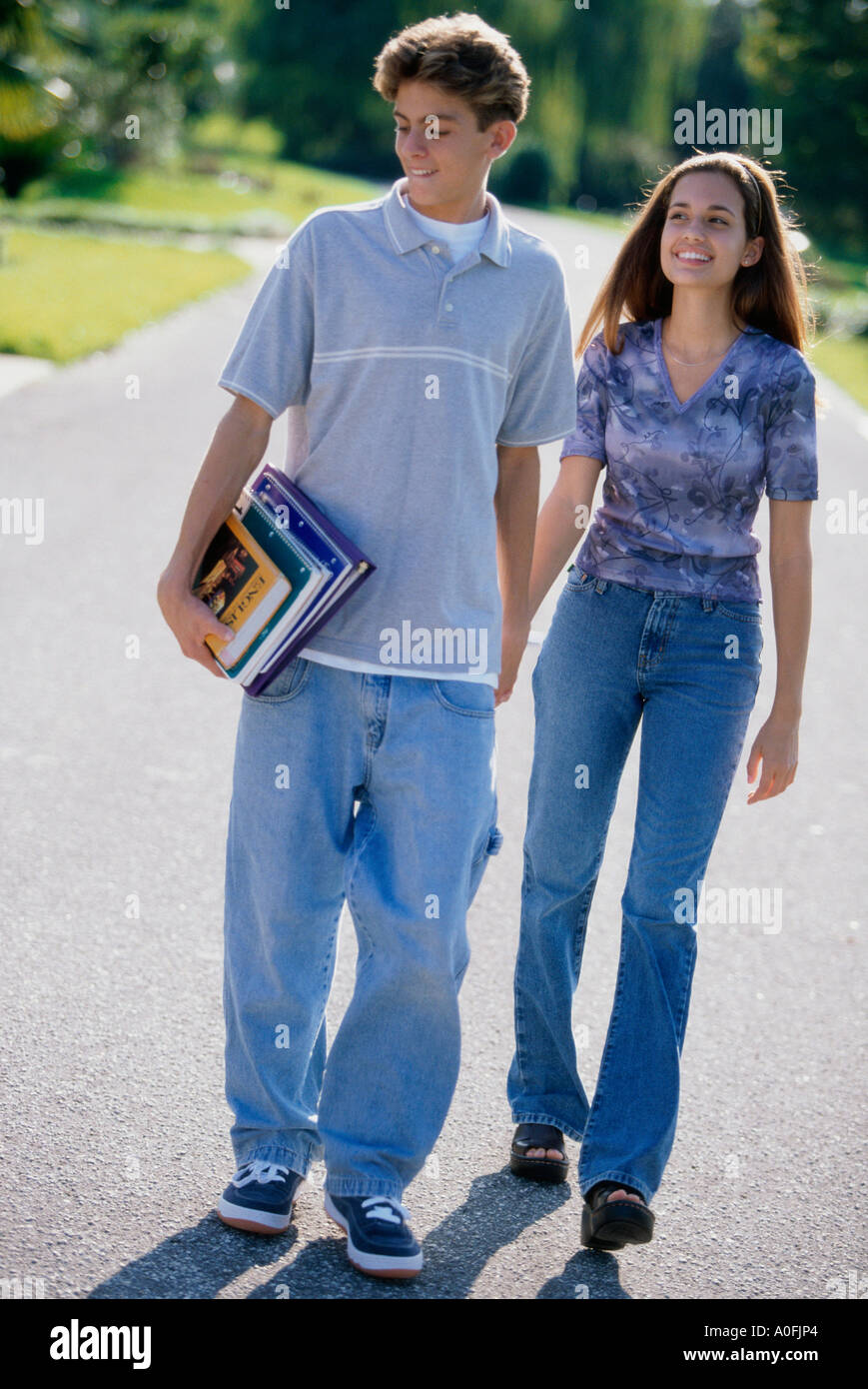 Teenage couple holding hands while walking outdoors Stock Photo - Alamy