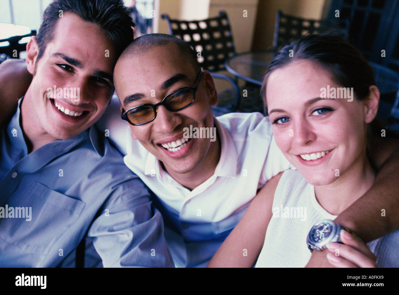Portrait of two young men and a young woman laughing Stock Photo - Alamy