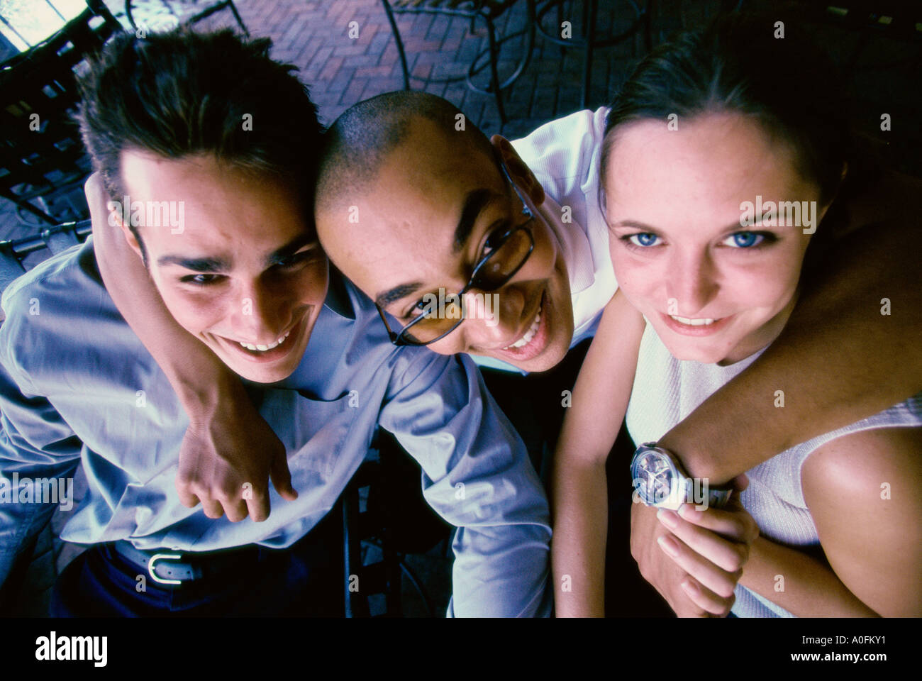 Portrait of two young men and a young woman smiling Stock Photo - Alamy
