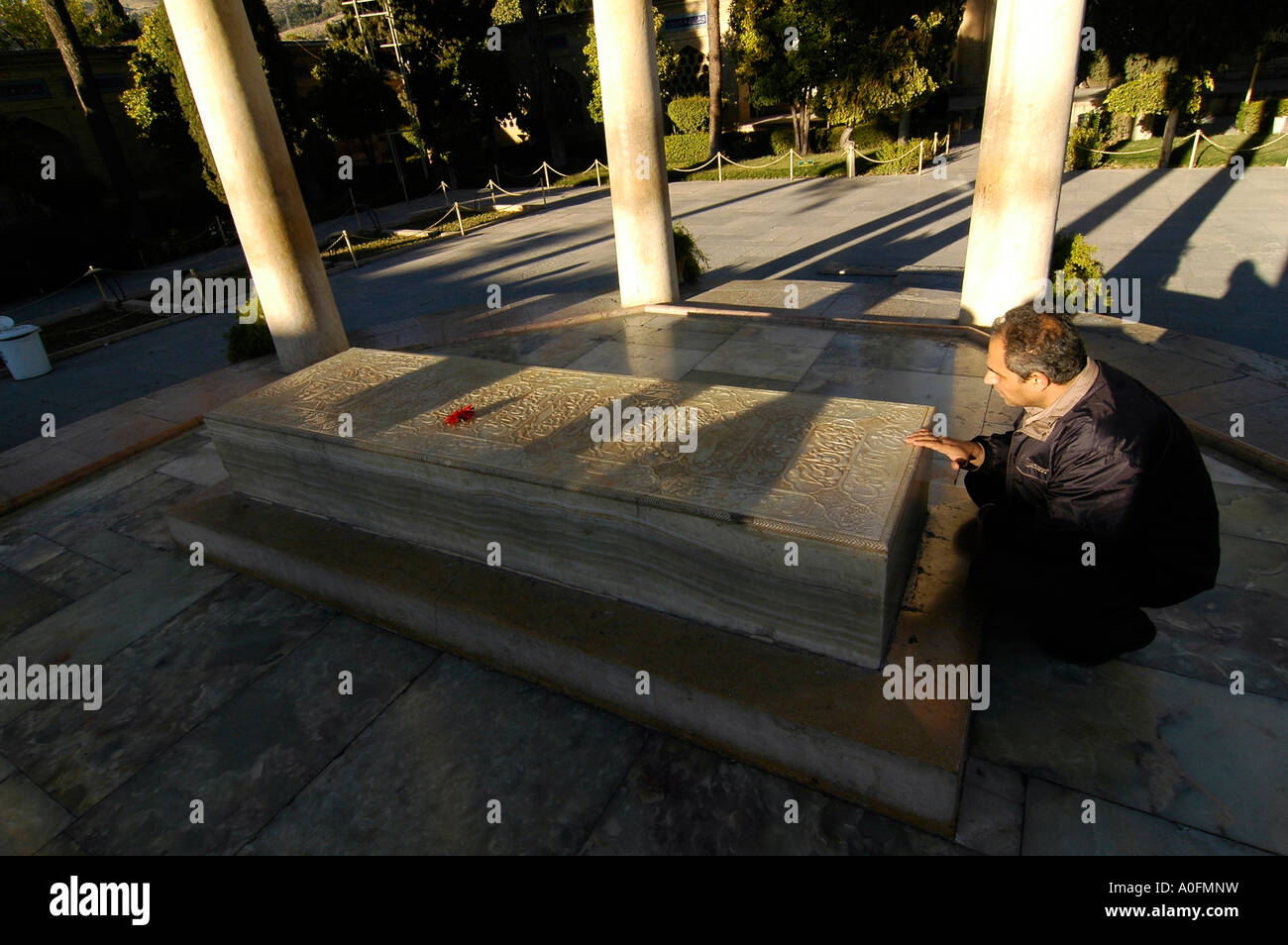 An Iranian man praying near the tomb of Hafez, a famous Persian poet who is revered by most Iranians, Shiraz, Iran Stock Photo