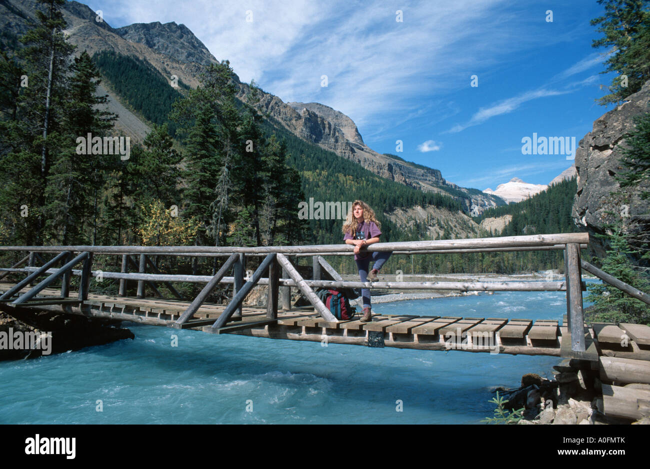 woman standing on a wooden bridge over river, Canada, Alberta, Banff NP Stock Photo