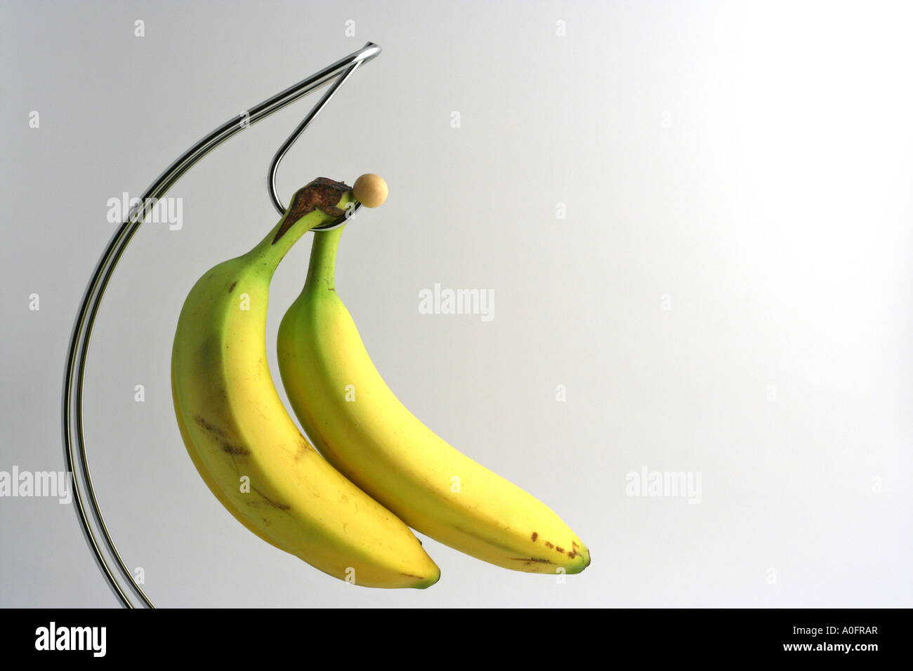 Three bananas on a curved banana stand Stock Photo Alamy