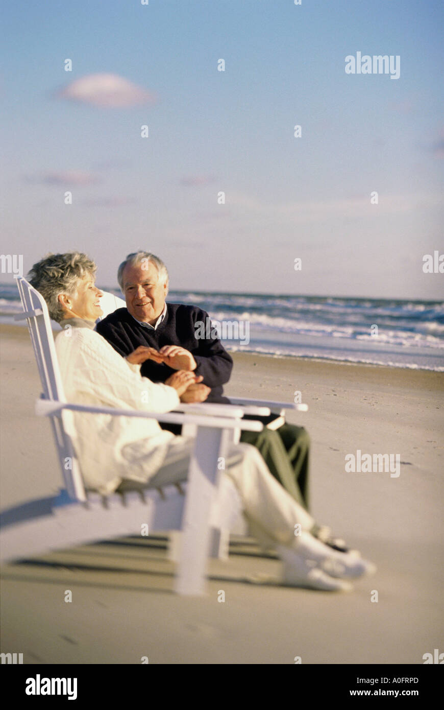 Senior couple sitting together on the beach Stock Photo - Alamy