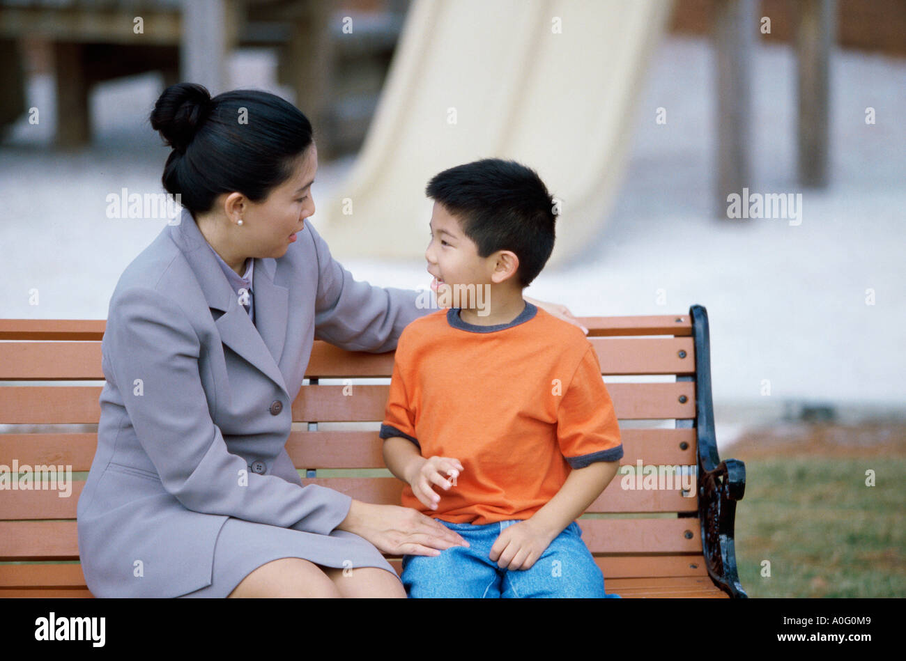 Mother sitting with her son on a park bench Stock Photo - Alamy