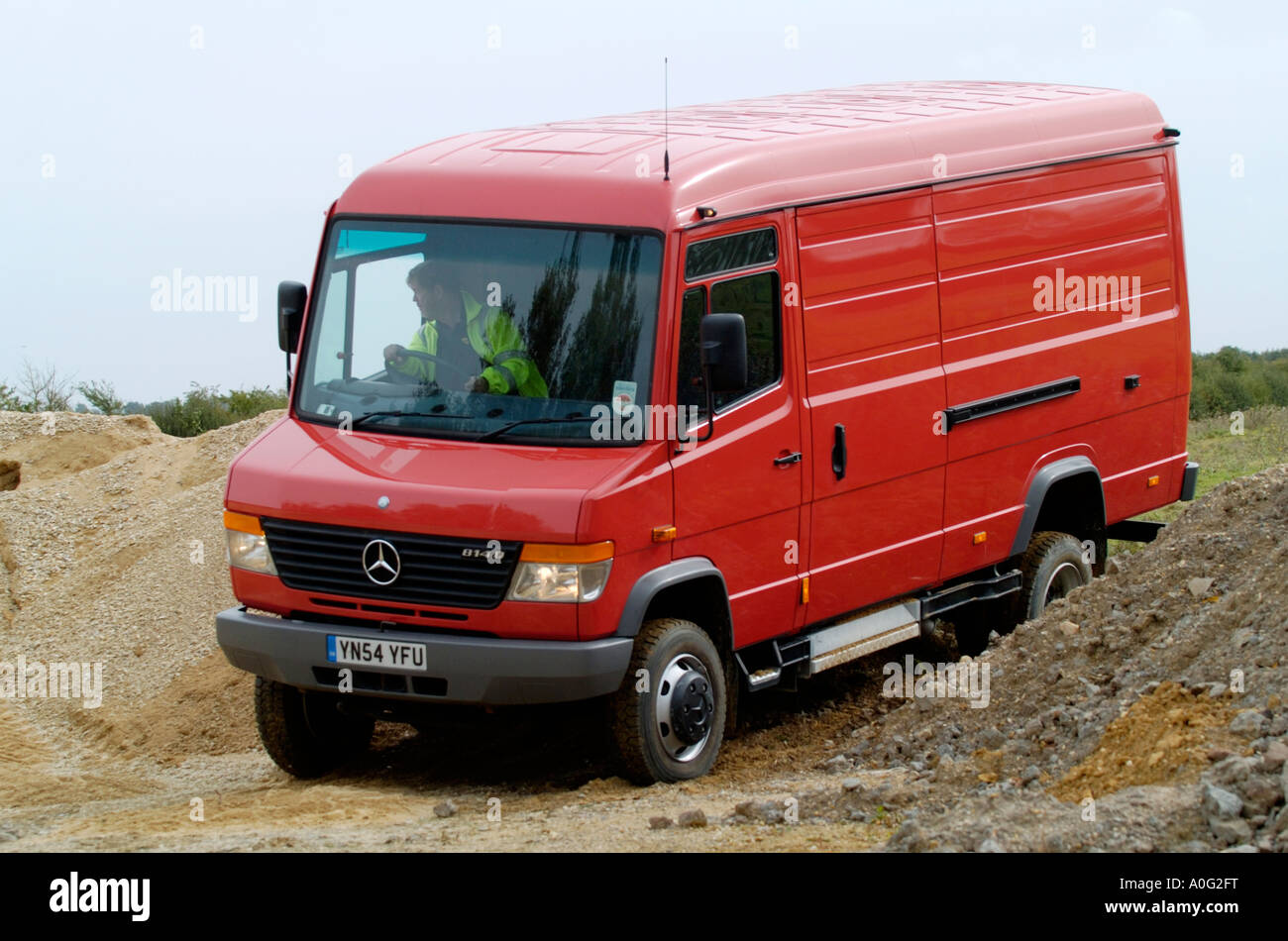 red mercedes 4x4 van travelling off road on difficult terrain Stock Photo