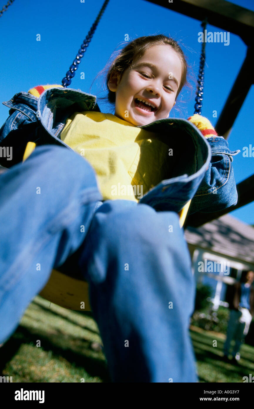 Low angle view of a girl sitting on a swing Stock Photo - Alamy