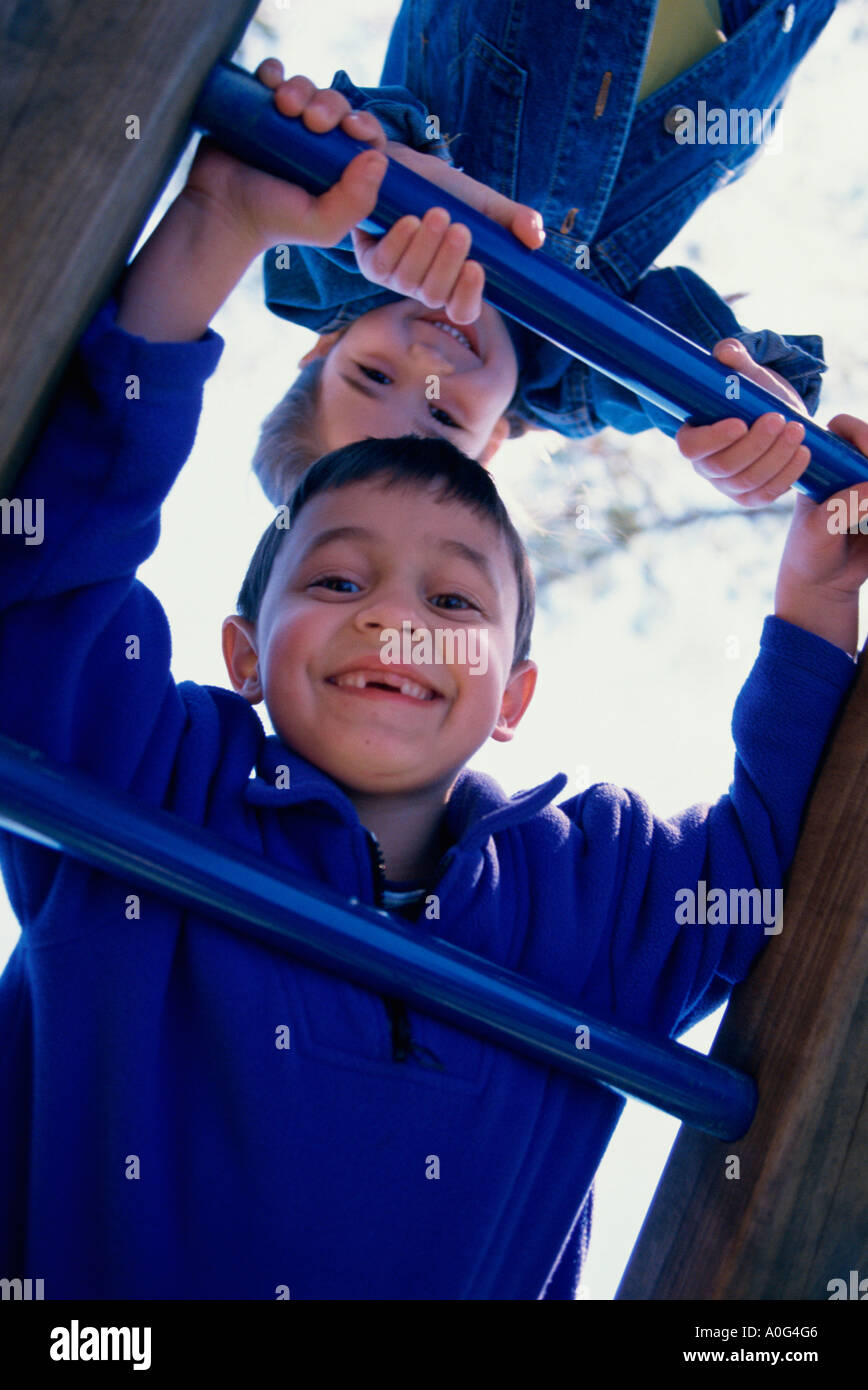 Portrait of a boy and a girl climbing on monkey bars Stock Photo Alamy