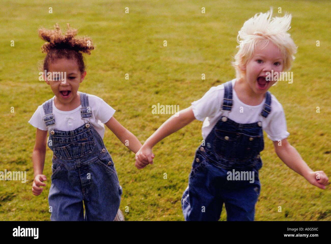 Two girls running on a lawn Stock Photo - Alamy