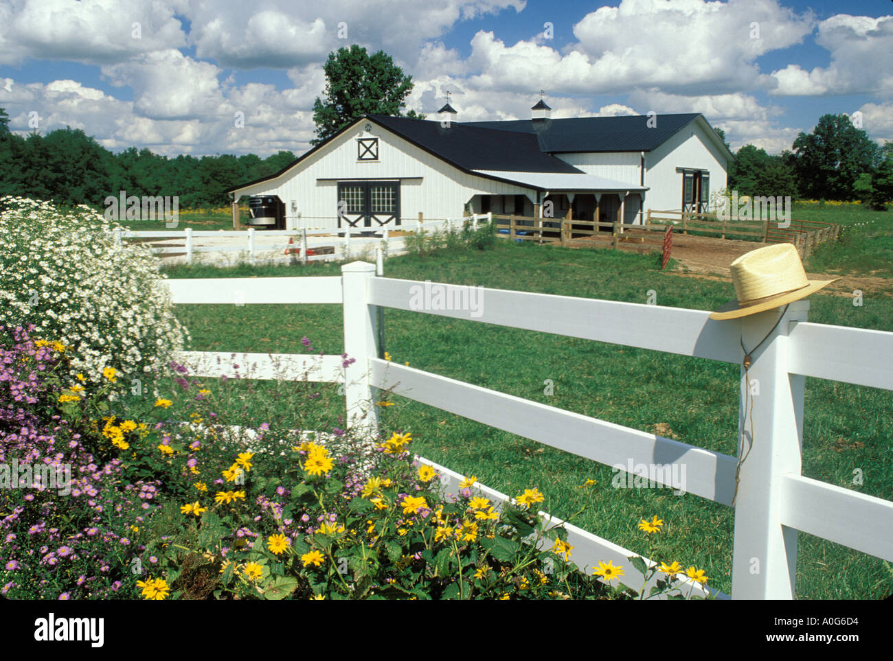Picturesque white barn as seen from house with white rail fence and
