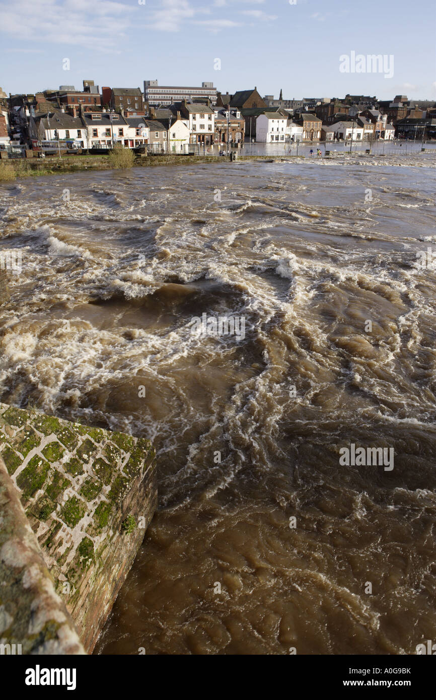 The raging torrent of the River Nith in flood looking across to flooded houses and businesses possible insurance claims UK Stock Photo