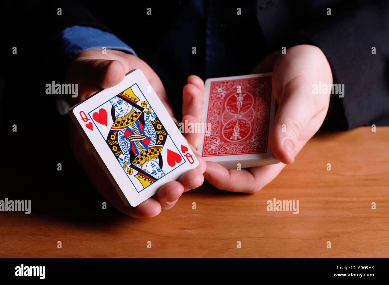 Man cutting deck of cards to queen of hearts Stock Photo Alamy