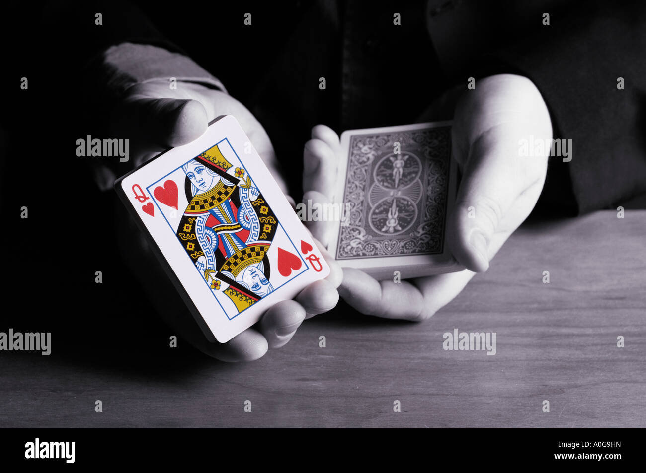 Man cutting deck of cards to queen of hearts Stock Photo Alamy