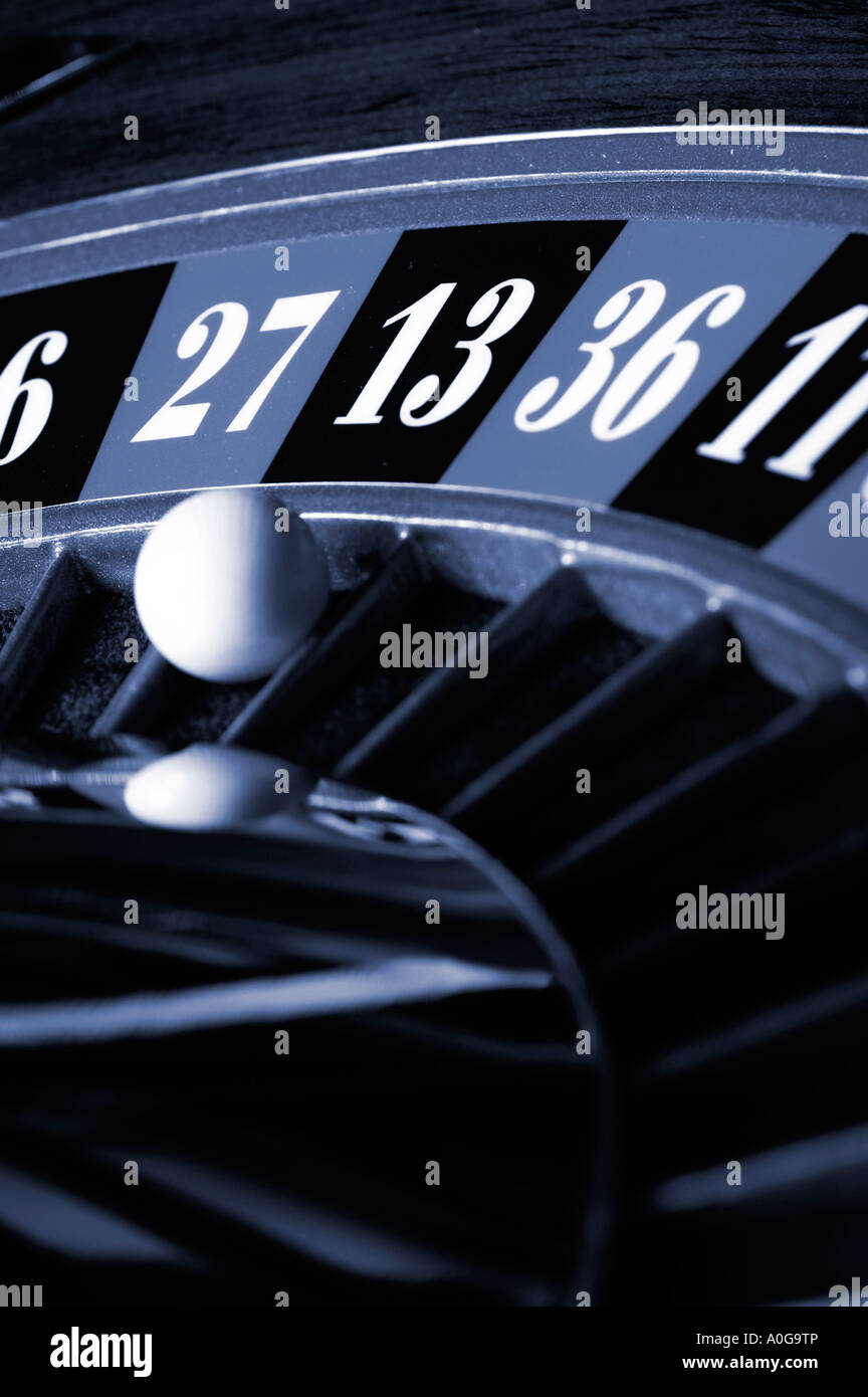 Roullette wheel spinning with ball in number thirteen blue toned Stock Photo