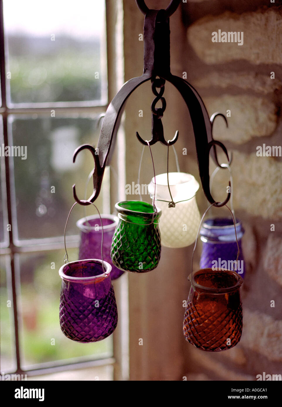 multi coloured tea lights hanging in windowsill Stock Photo Alamy