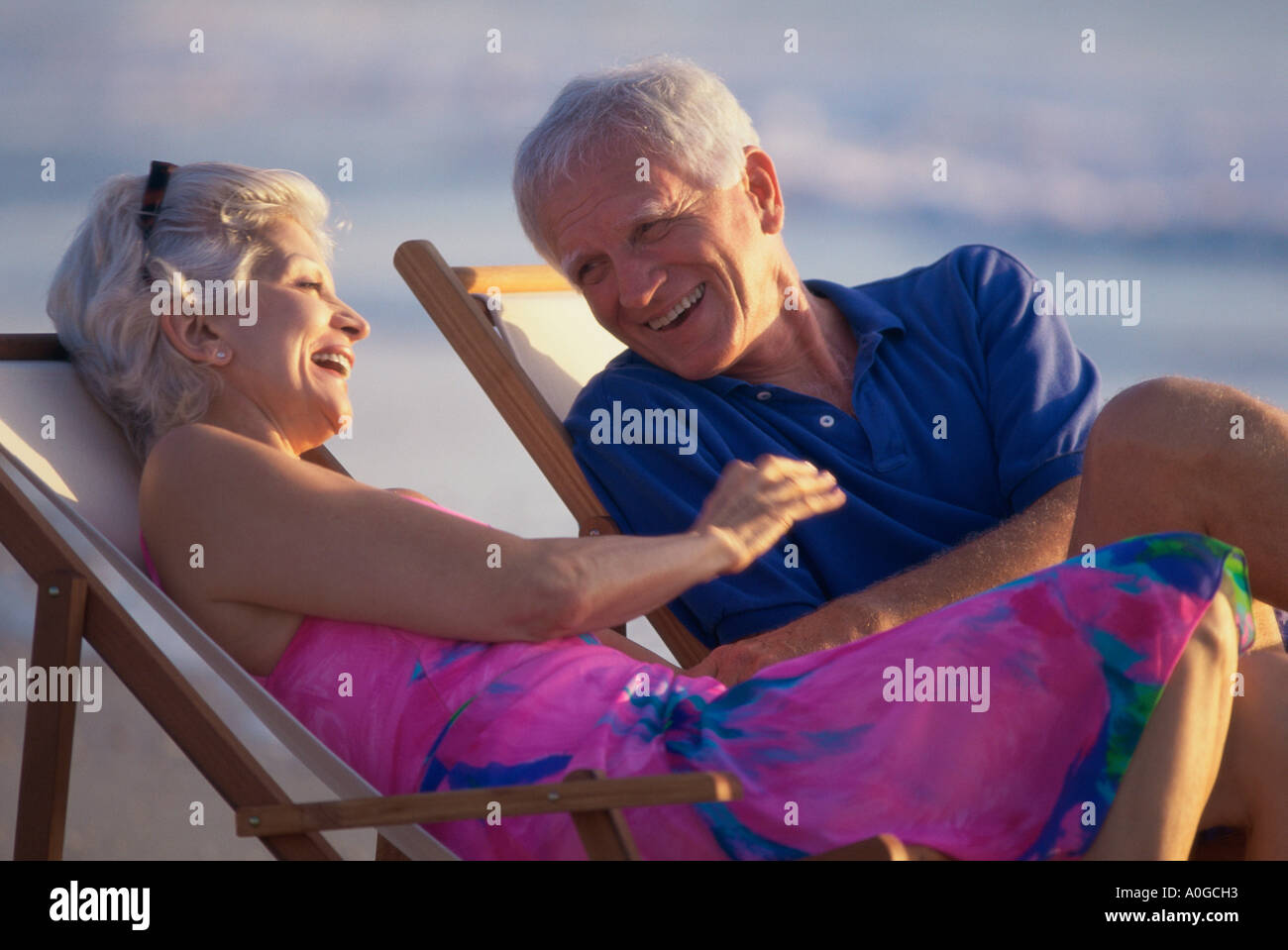 Senior couple sitting in deck chairs on the beach Stock Photo - Alamy