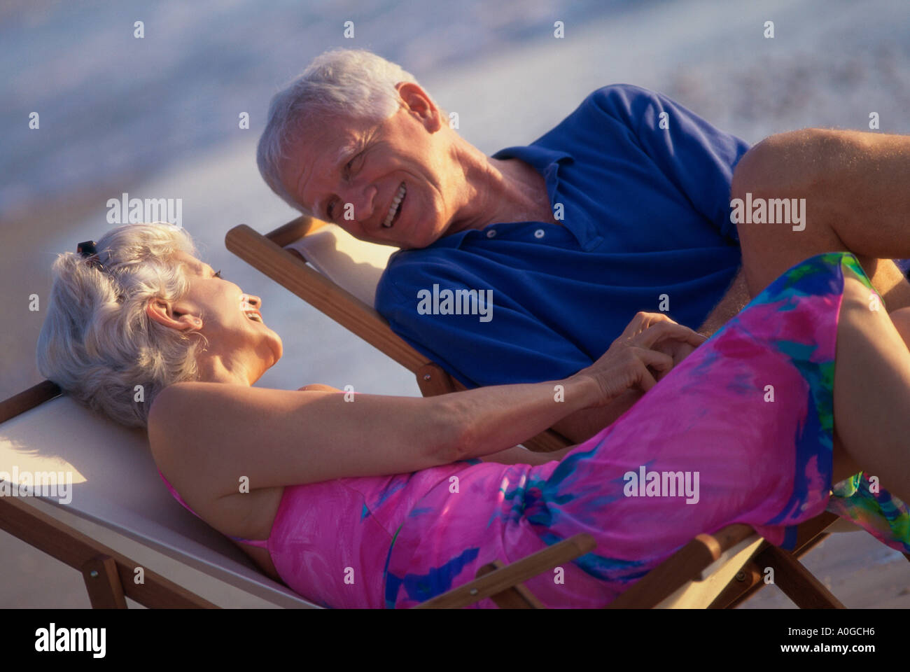 Senior couple sitting in deck chairs on the beach Stock Photo - Alamy