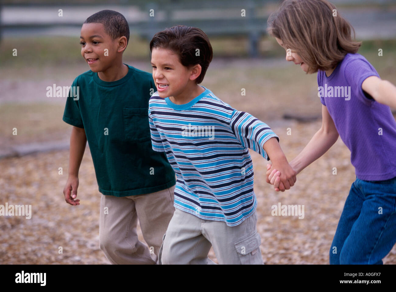 Two boys and a girl running holding hands Stock Photo - Alamy