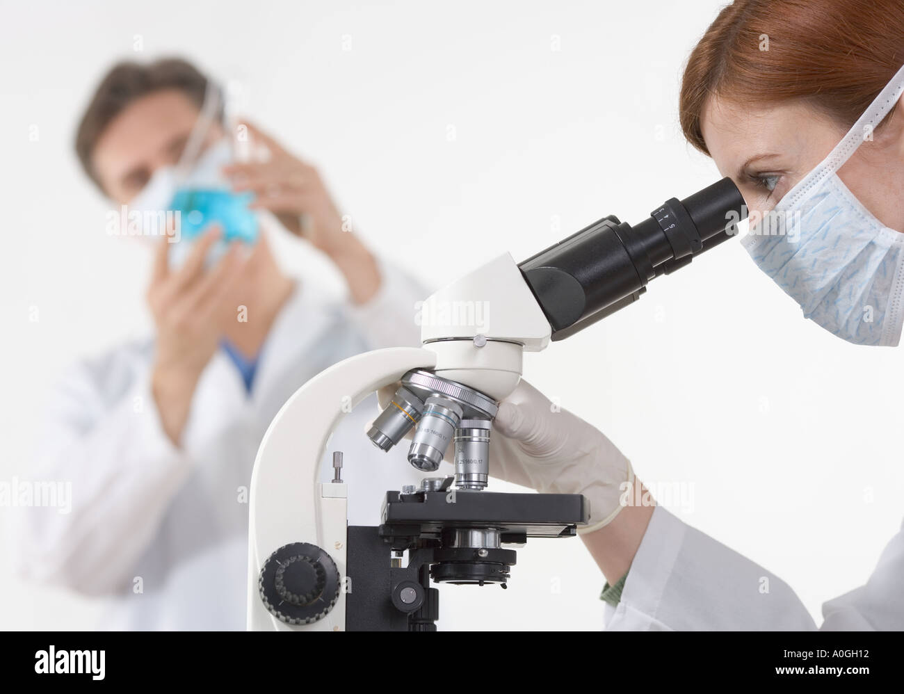 Scientists in laboratory with microscope Stock Photo