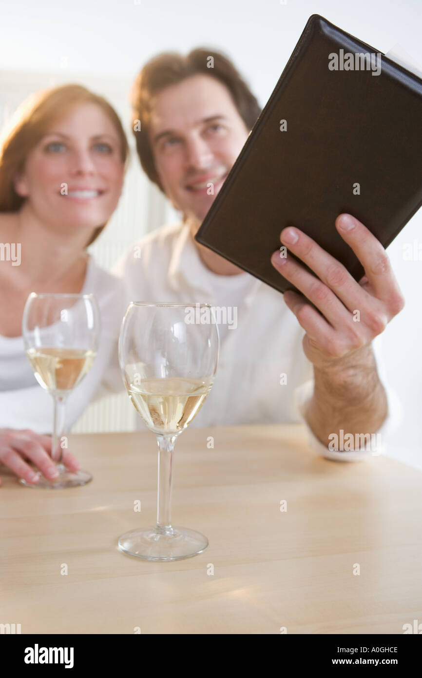 Couple with wine paying their bill Stock Photo