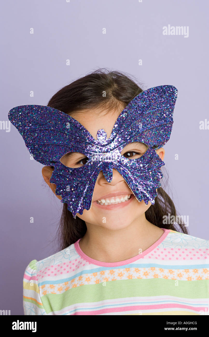 Girl wearing a butterfly eye mask Stock Photo