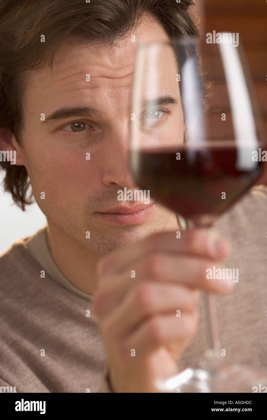 Closeup of man scrutinizing red wine Stock Photo