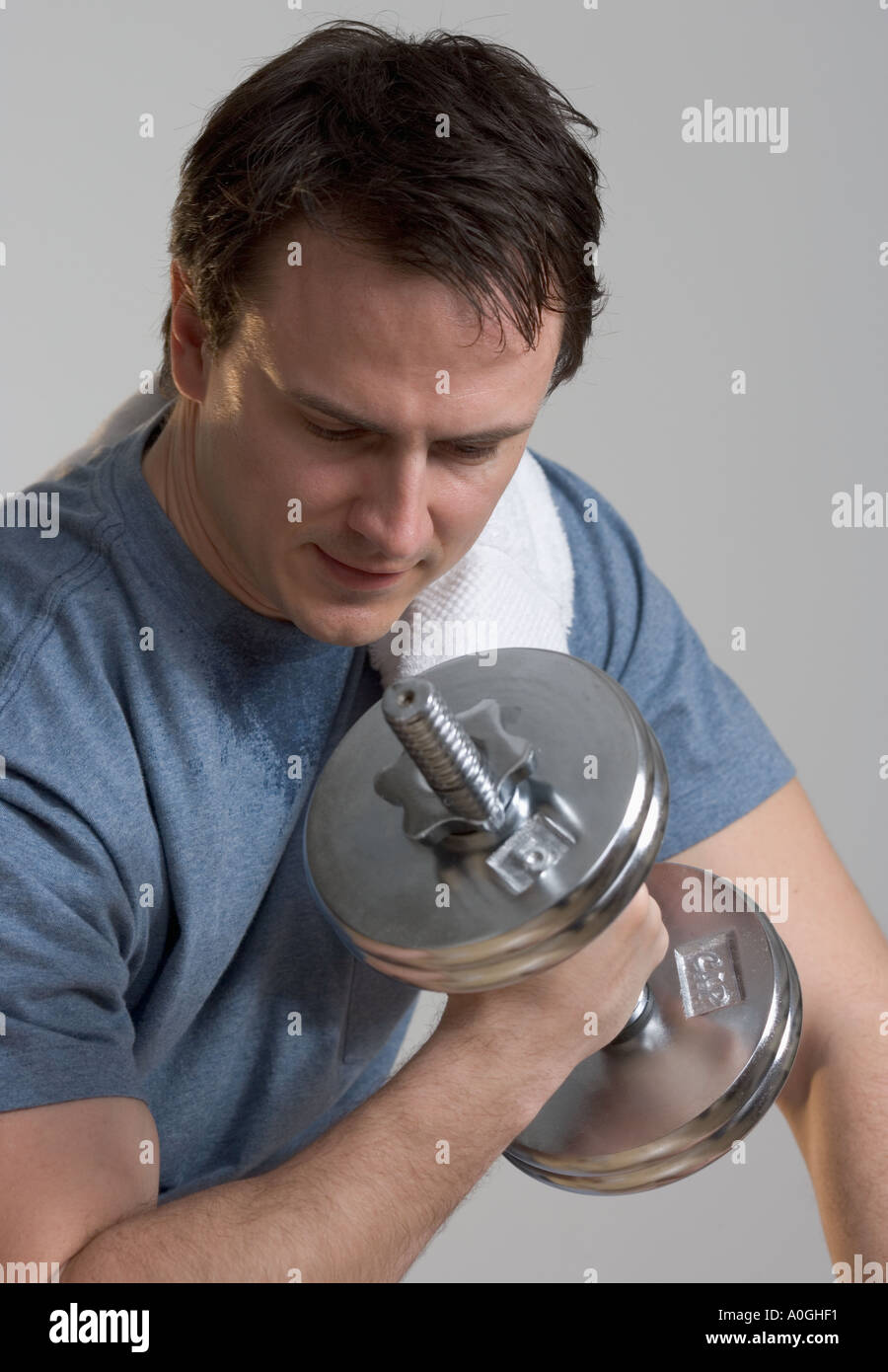 Sweating man lifting weights Stock Photo