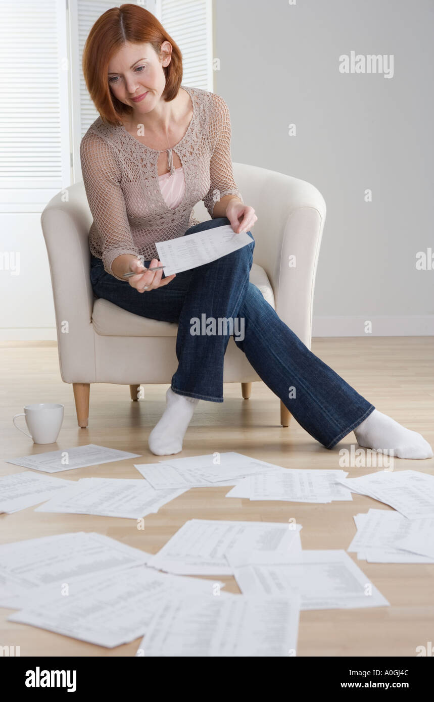 Redheaded woman sorting papers on floor Stock Photo