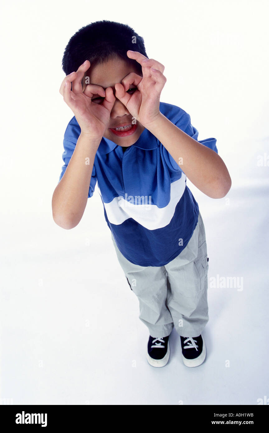 High angle view of a boy holding his hands up to his eyes Stock Photo ...