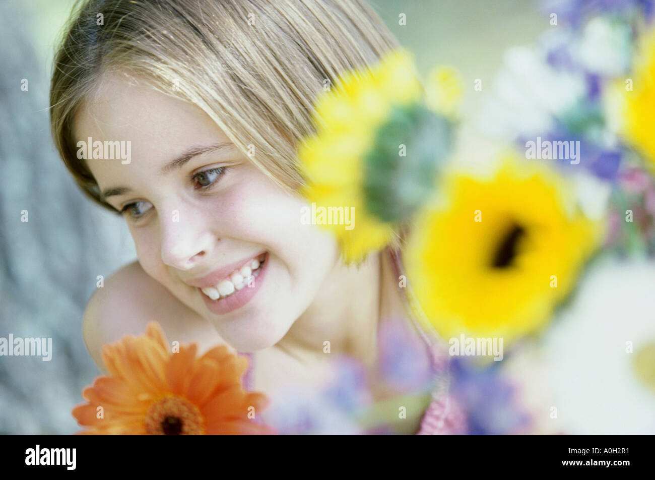 Girl smiling with flowers in front of her Stock Photo - Alamy