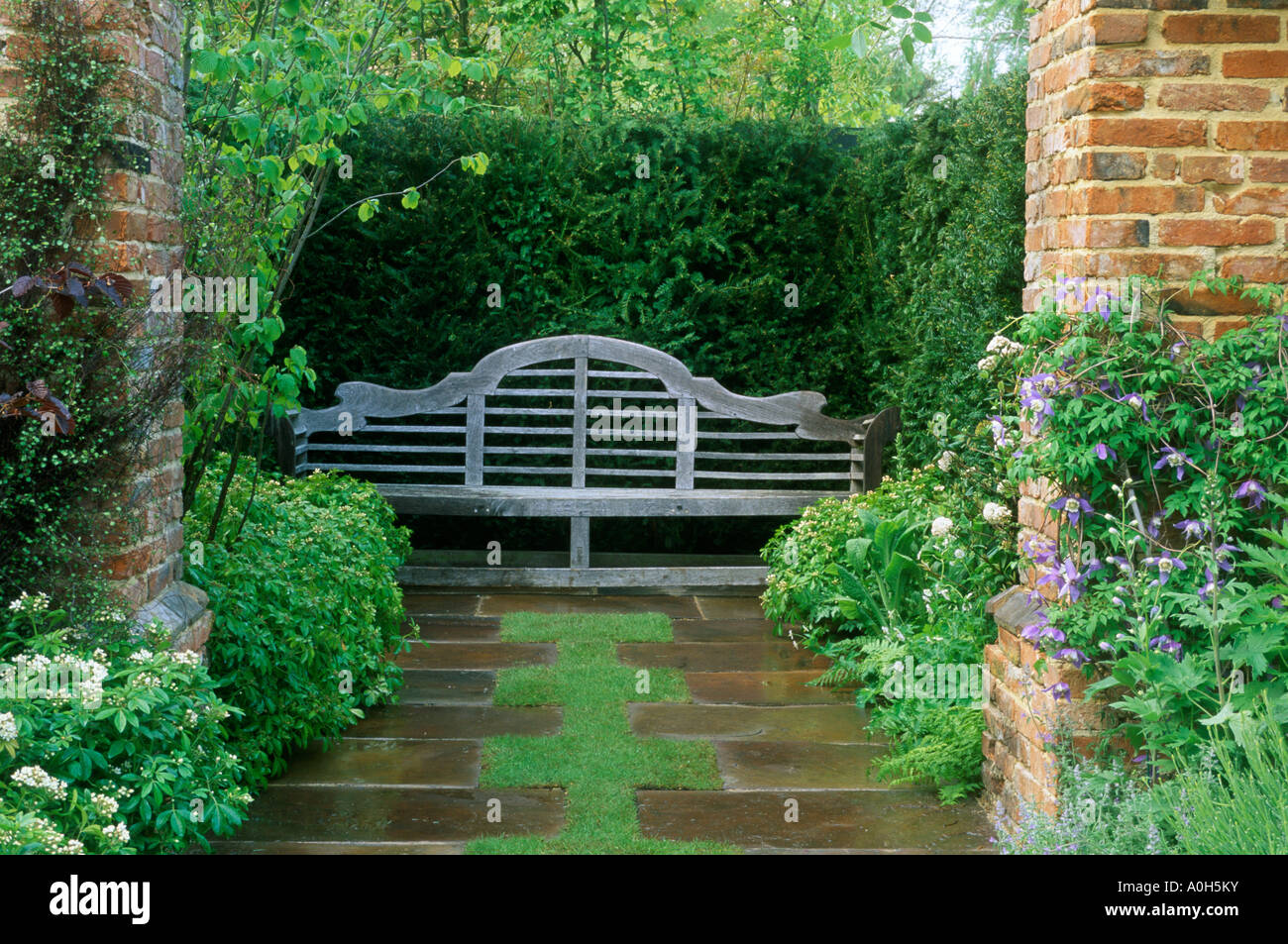 Chelsea FS 1996 Design Mark Walker Lutyens bench at end of stone path in secluded corner next to tall yew hedge Stock Photo