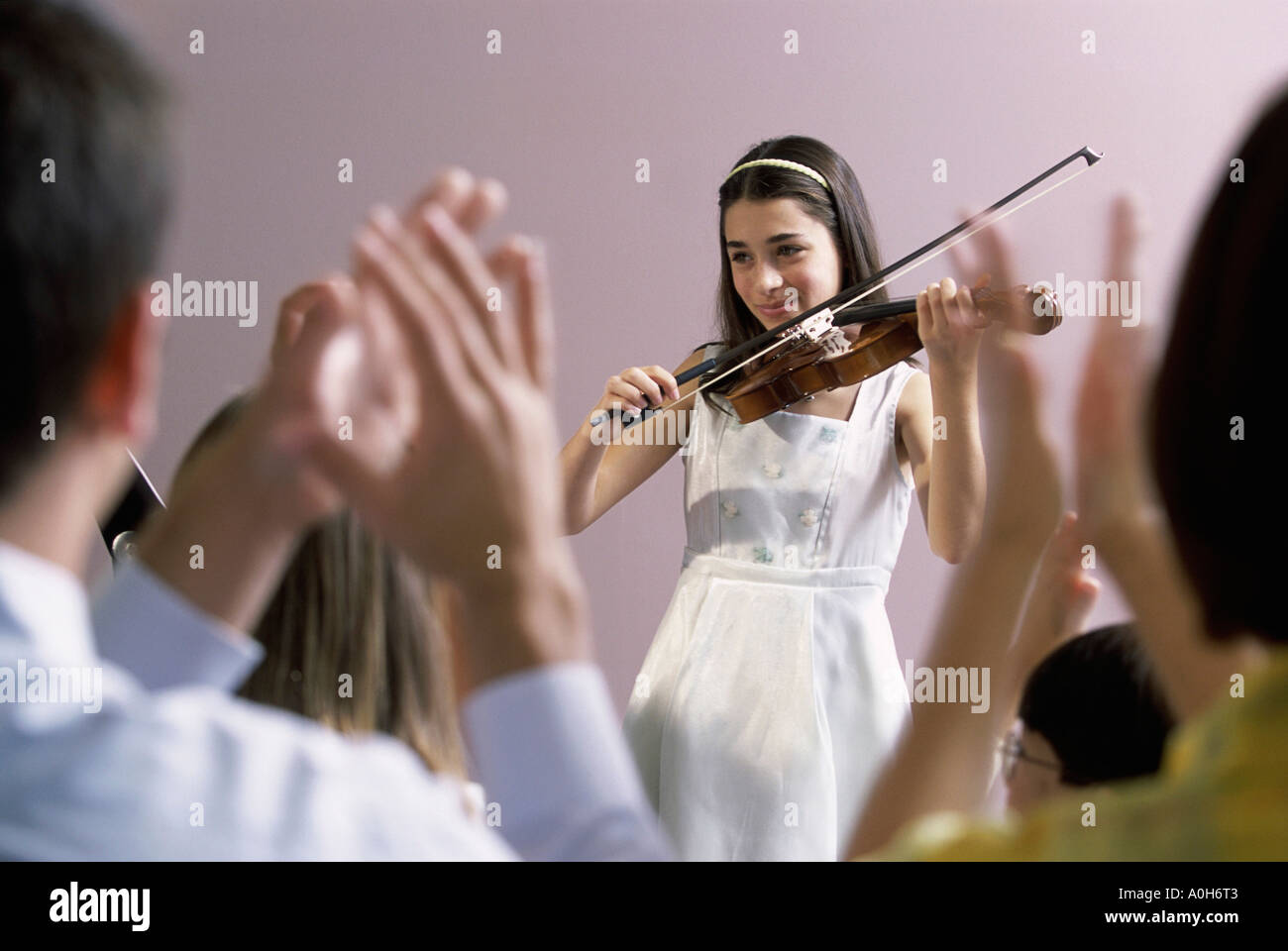 Girl playing a violin in front of an audience Stock Photo