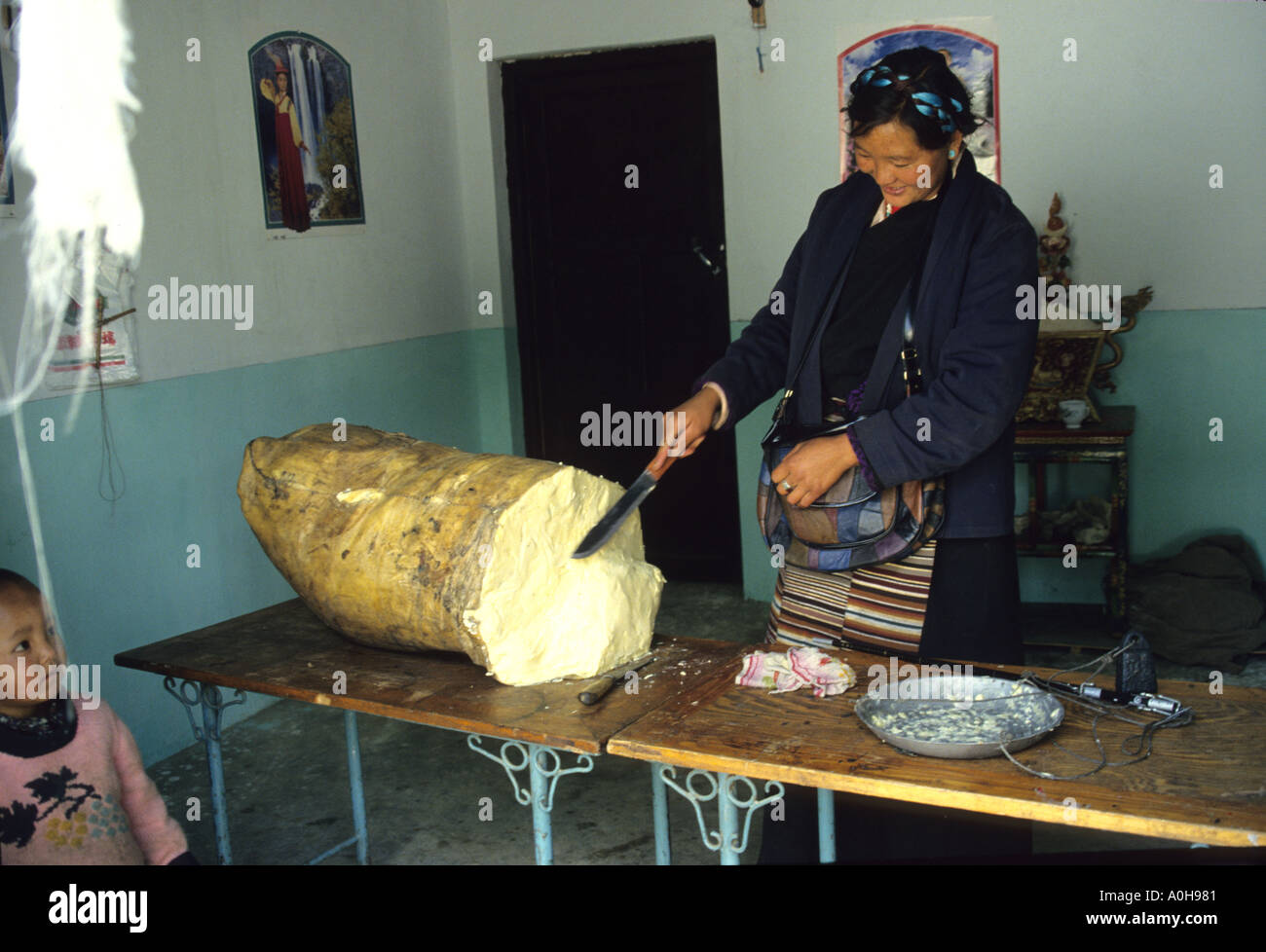 Tibetan woman selling Yak butter from a large roll contained in sacking