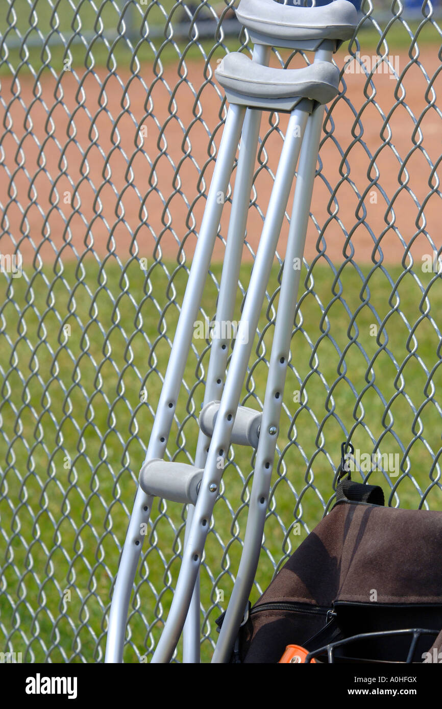 A set of Crutches leaning against a chin link fence Stock Photo Alamy