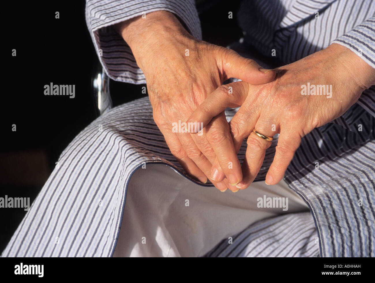 elderly man alone, in a wheelchair, during the pandemic lockdown, isolated because of illness Nursing home patient in a bathrobe. Stock Photo