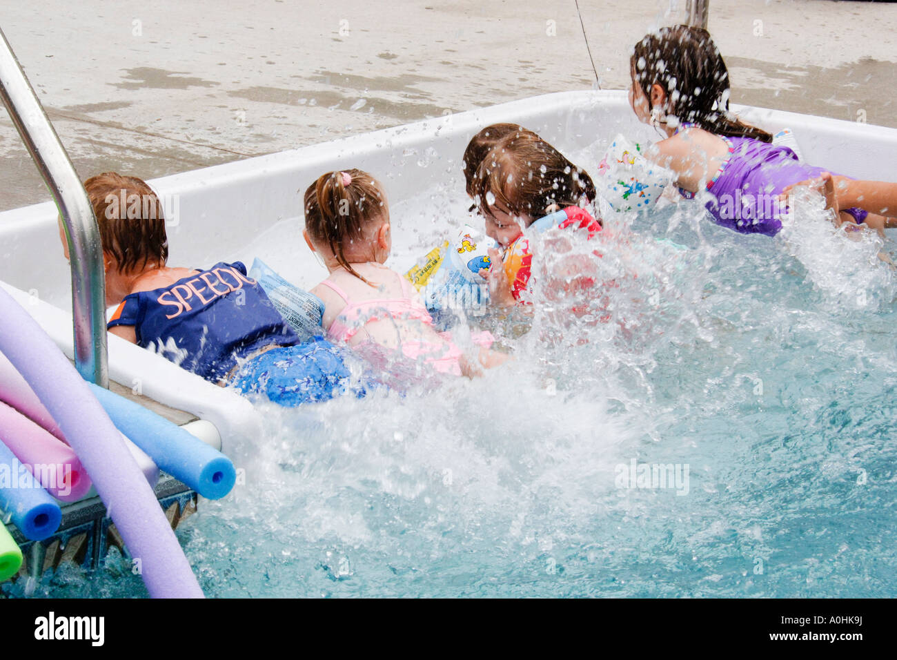 PreK Children at the edge of a swimming pool exercising their leg