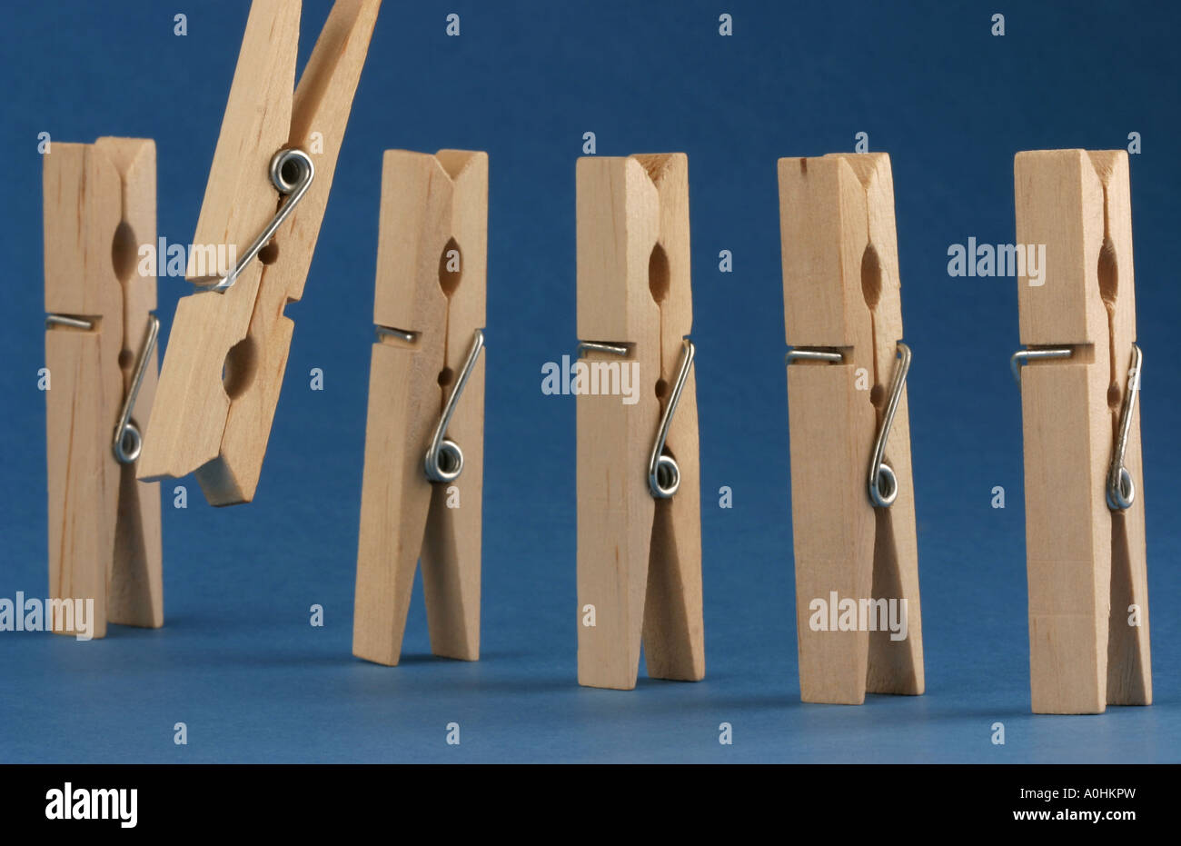 Wooden clothes pegs standing in a row Stock Photo