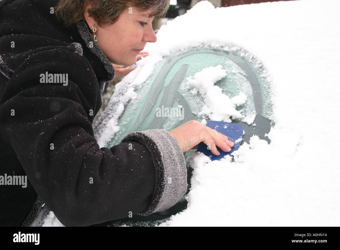 Clearing the windscreen after heavy snow Stock Photo