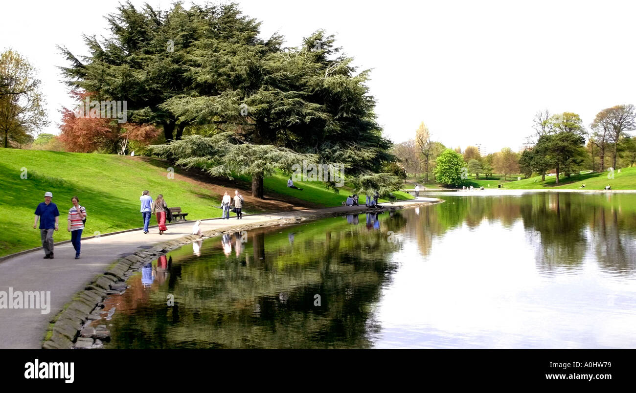 Couples stroll by the lake in Sefton Park Liverpool Stock Photo
