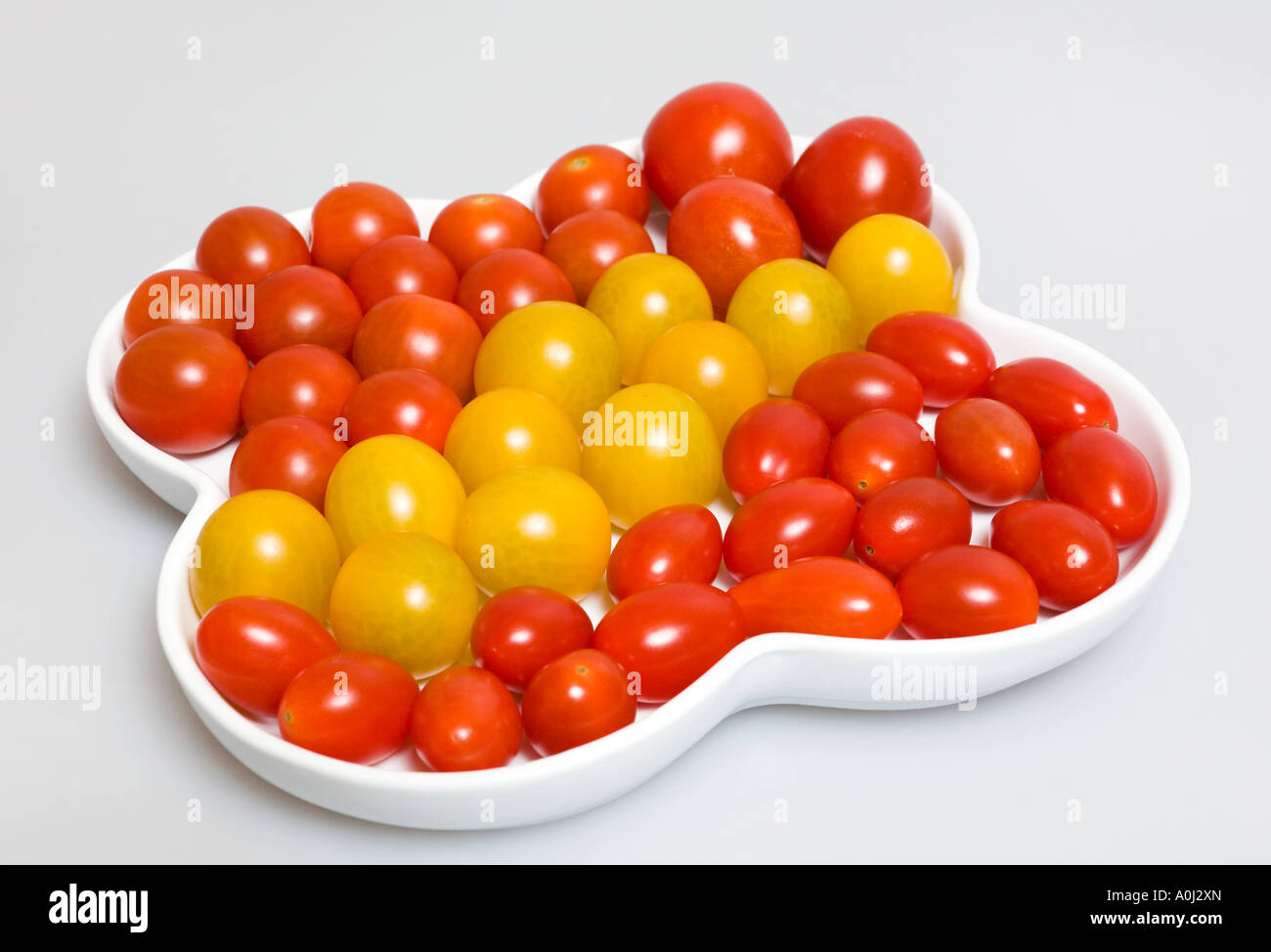 Several small sorts of tomatoes in a porcelain dish Stock Photo