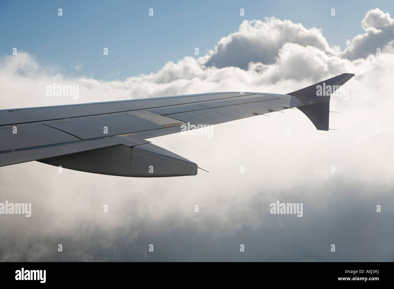 Wing of airplane above clouds Stock Photo