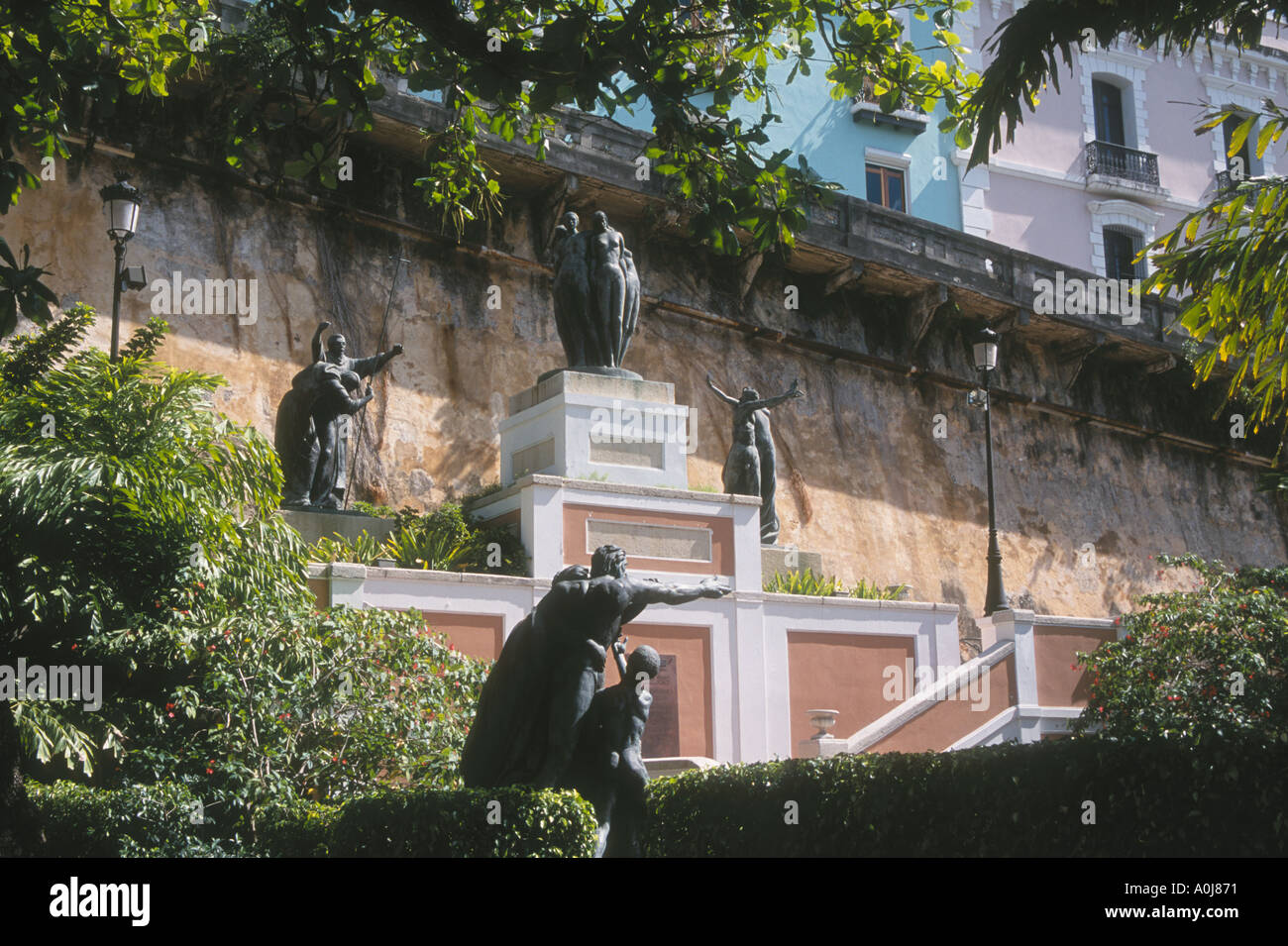 Statues in park on Paseo la Princesa with colorful houses in background Old San Juan Puerto Rico Stock Photo
