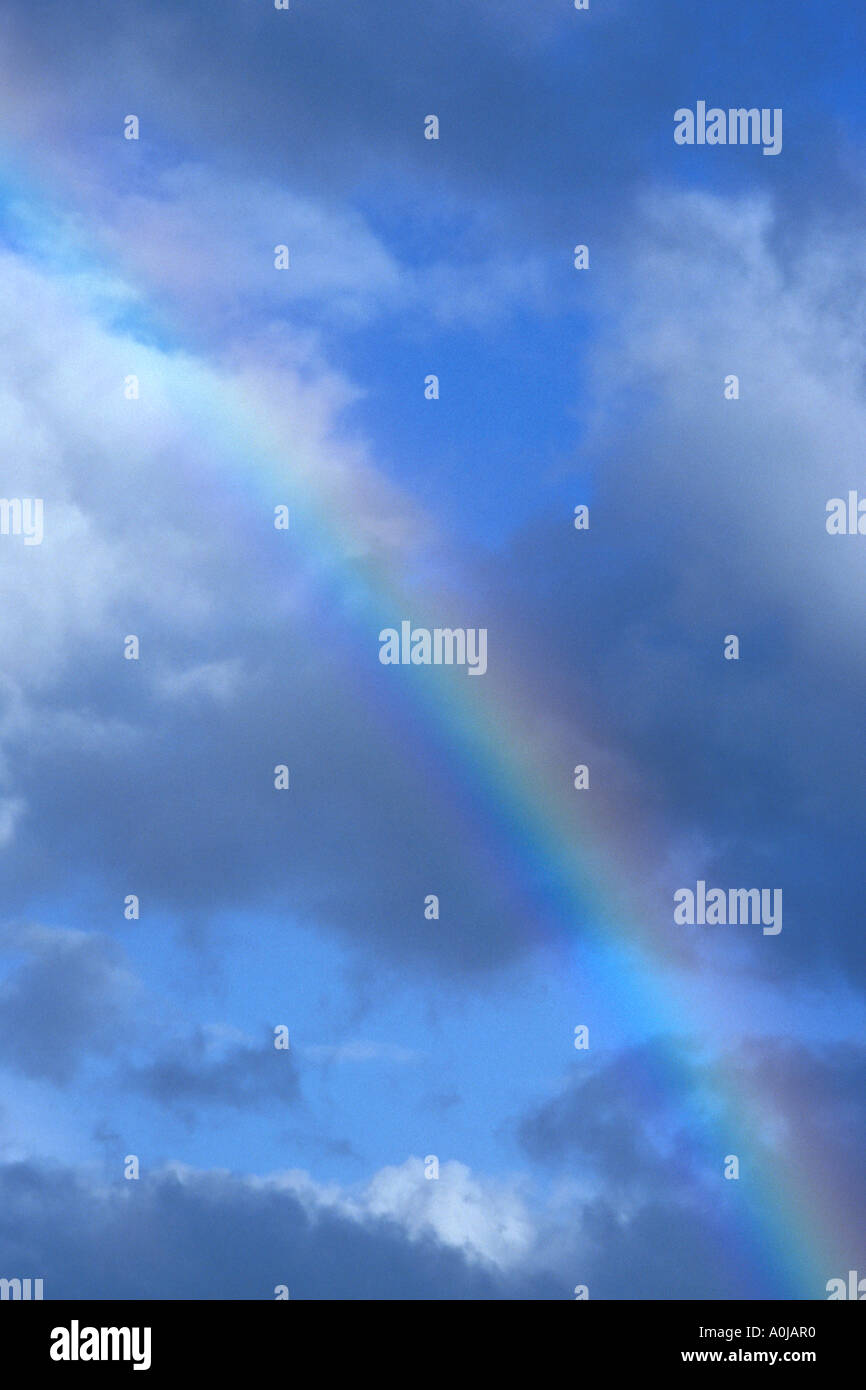 rainbow in blue sky with soft clouds Stock Photo - Alamy