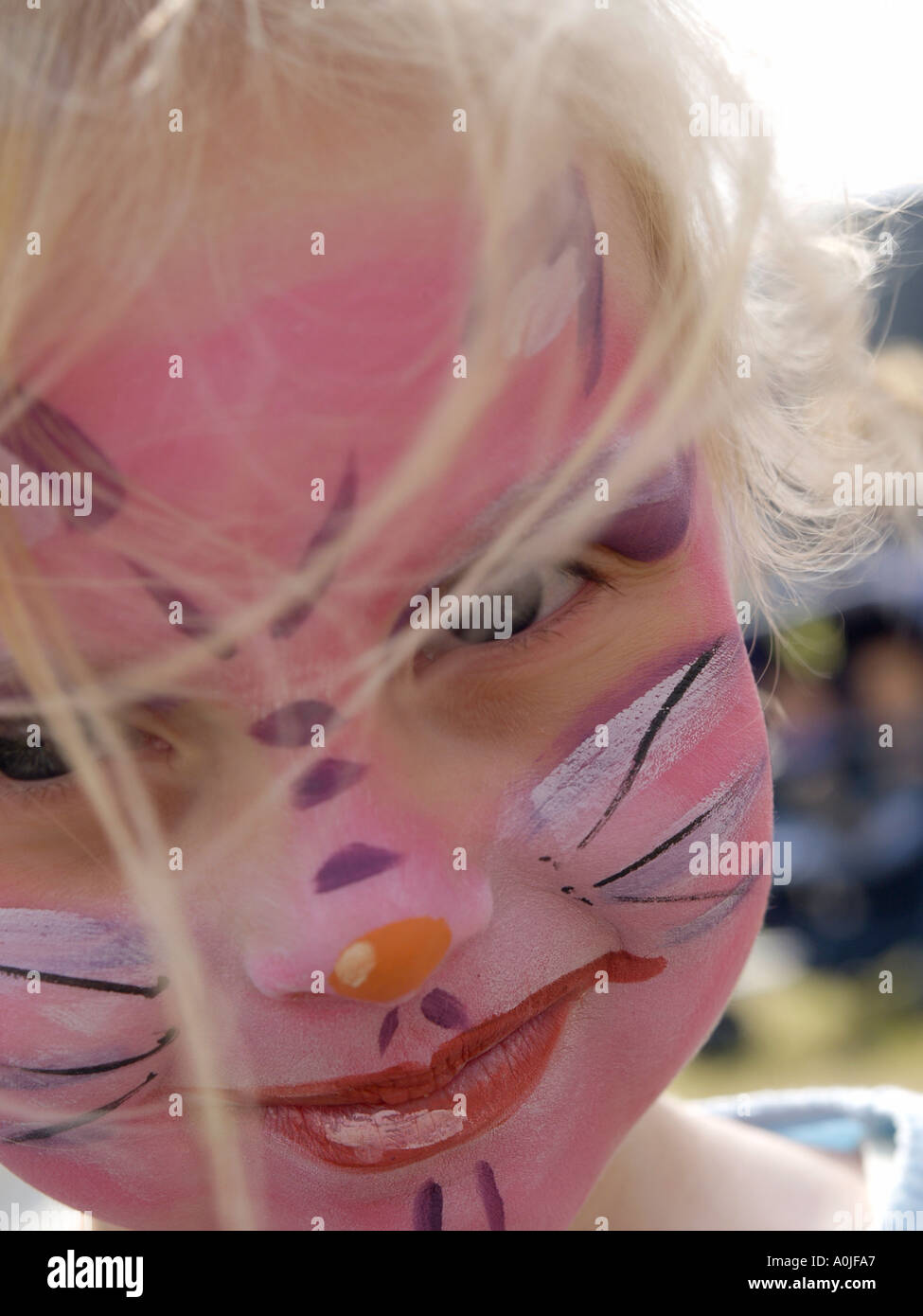 Young girl cat woman with pink panther make up on her face smiling to the camera Stock Photo