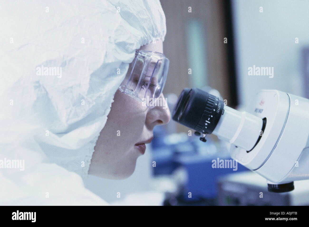 Side profile of a female researcher looking through a microscope Stock ...