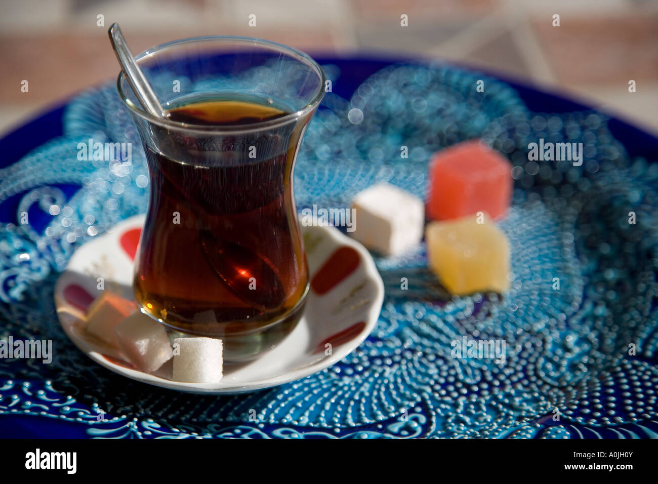 A glass of Turkish Tea and cubes of Turkish Delight Loukoum